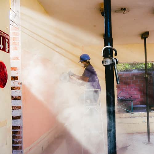 Volunteer-Sanding-Texas-School-Tools.jpg International volunteer sanding the interior walls of a school