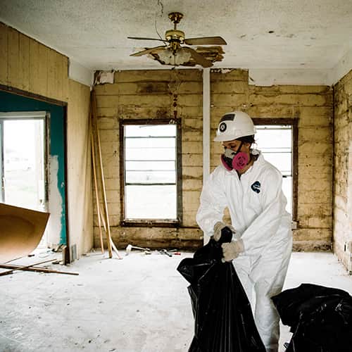 Voluntario internacional desinfectando el interior de una casa en Texas después del Huracán Harvey