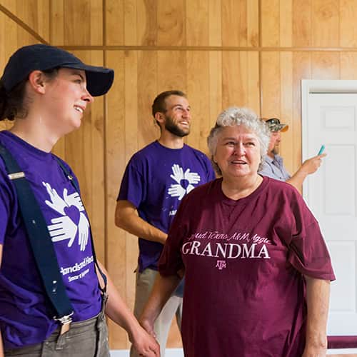 An international volunteer smiling and interacting with a survivor in Houston, Texas after Hurricane Harvey