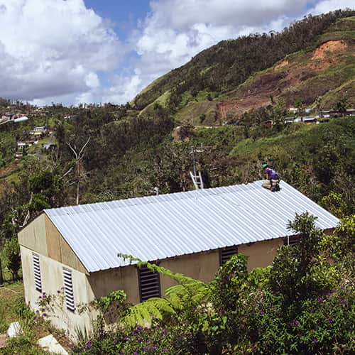 An international volunteer completing the roofing of a building in Puerto Rico