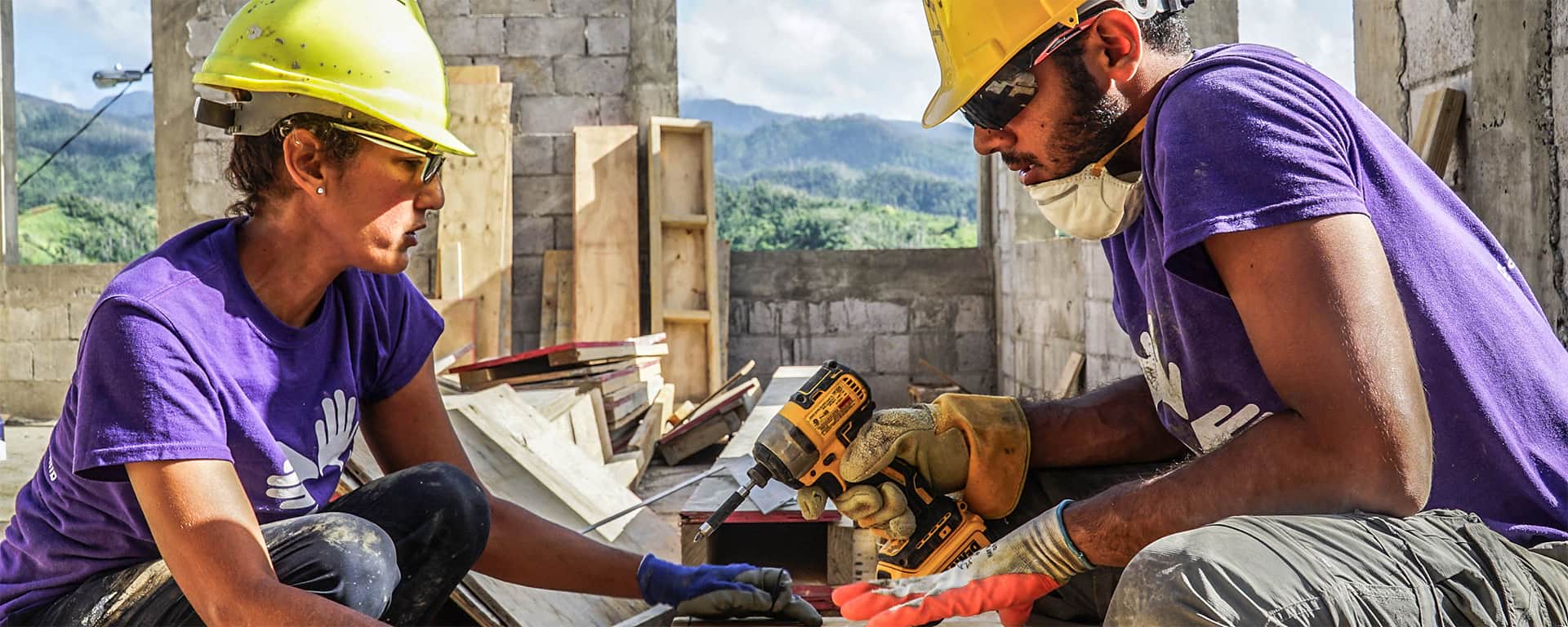 Volunteer-Drilling-Teamwork.jpg International volunteers drilling the exterior framework of a home being rebuilt