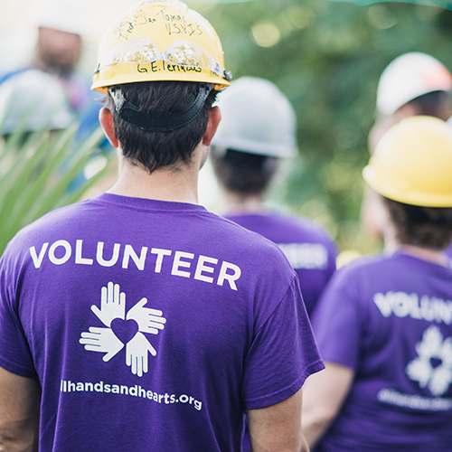 Un voluntario internacional que lleva la camiseta de voluntario de la marca "All Hands and Hearts - Respuesta Inteligente".