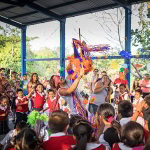 Volunteer-Children-Celebration-Piñata-Mexico.jpg A volunteer smashing a piñata amongst a celebration with young school children in Mexico