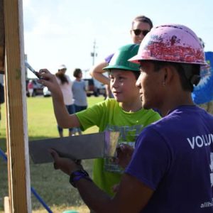 All Hands and Hearts - Smart Response volunteer painting with a student