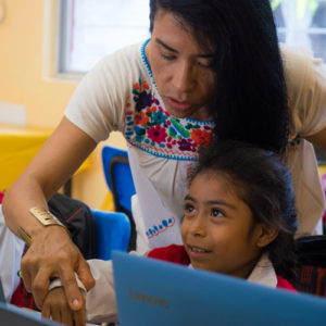 Ateacher helping a student and working together in a classroom