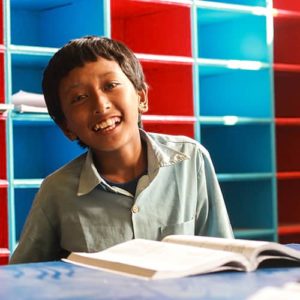 A young, smiling student of Nepal smiling in a classroom of a newly-built school