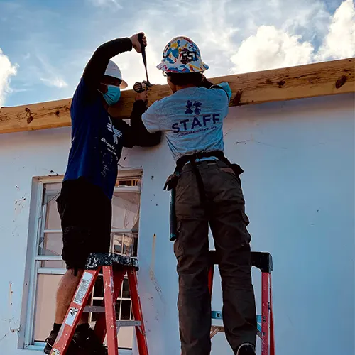 Two volunteers fixing a roof