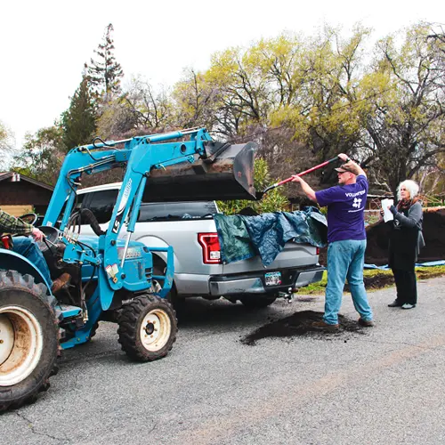 voluntario cargando mantillo en la parte trasera de un camión