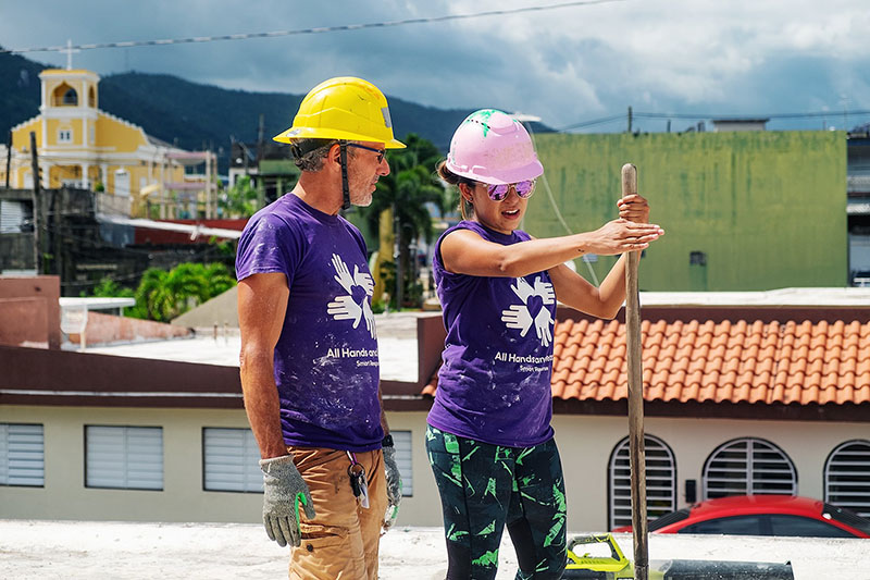 Two volunteers sealing a roof