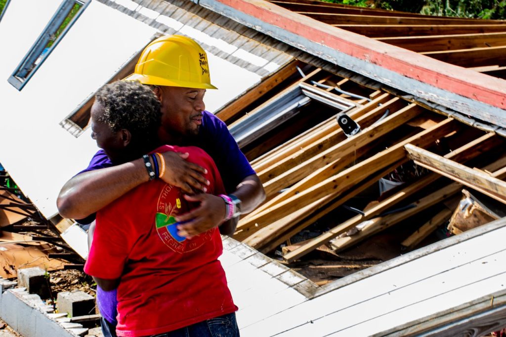 Disaster relief volunteer hugging a homeowner