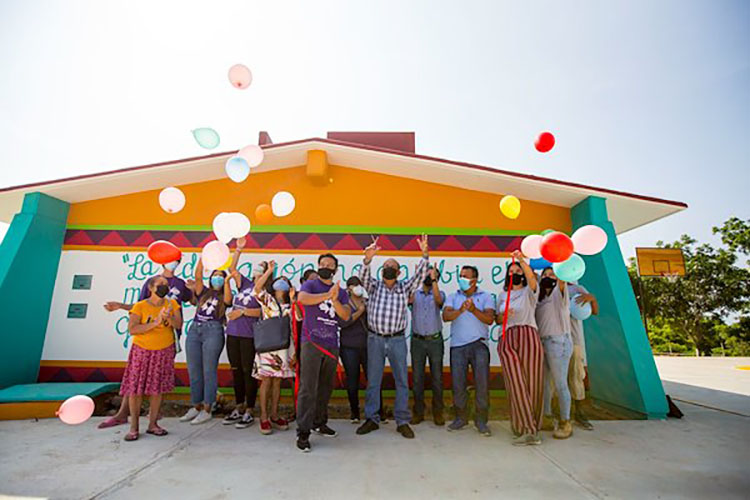 Group photo of people celebrating the completion of a school