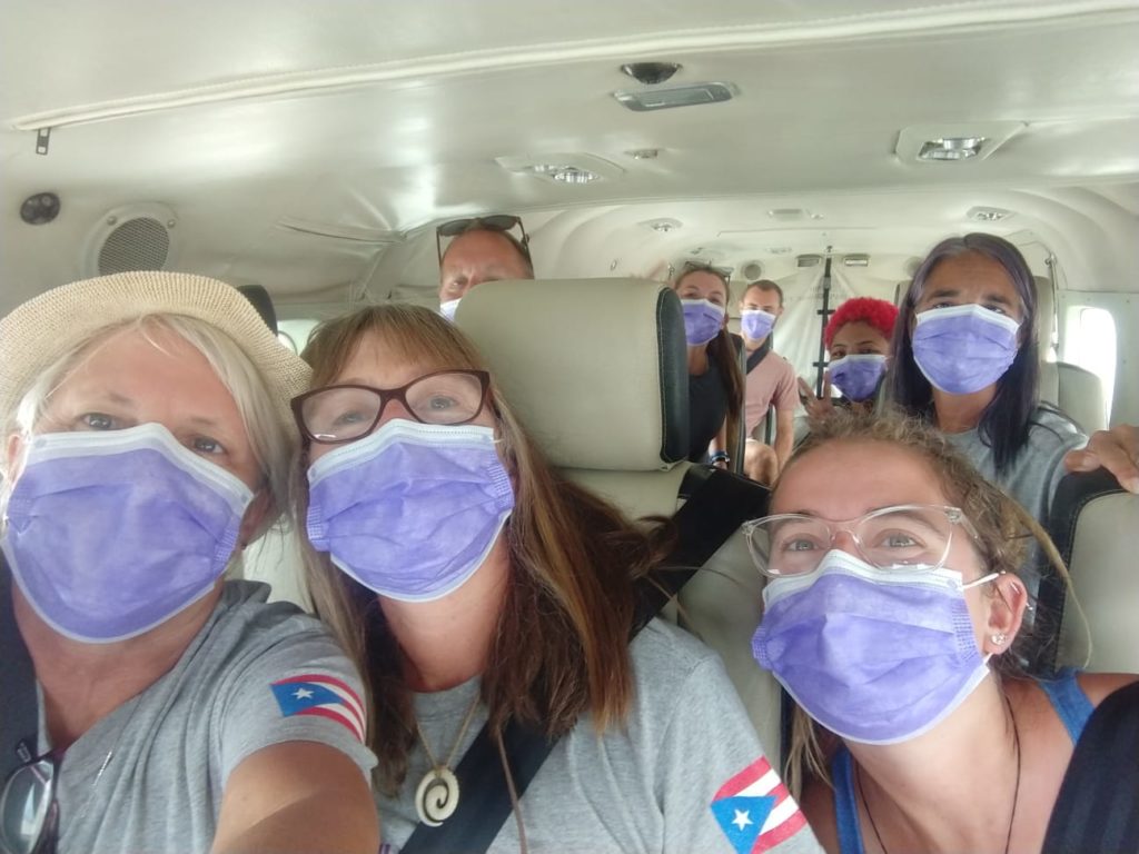 masked volunteers in van on the way to a job site