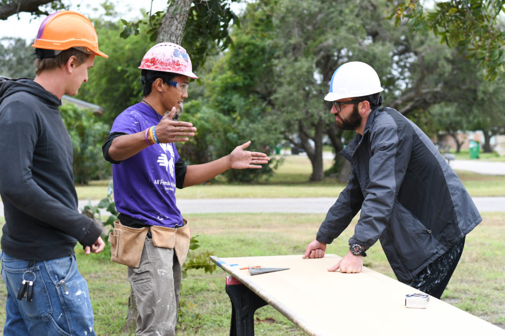 Staff having a safety talk with two volunteers