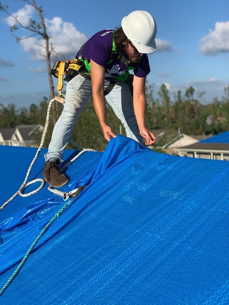 volunteer tarping a roof