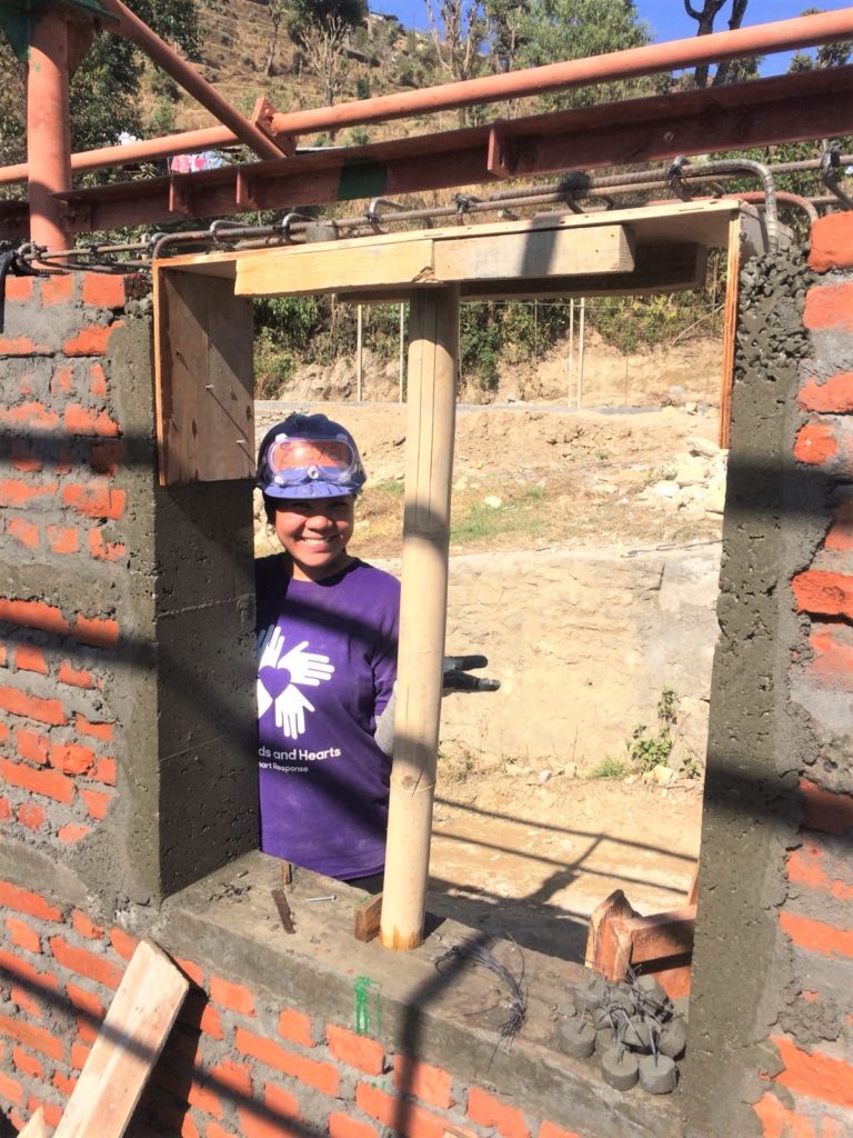 volunteer behind a partially built window