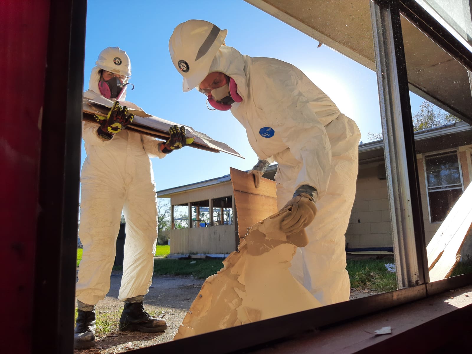 People loading debris in tyvek suits