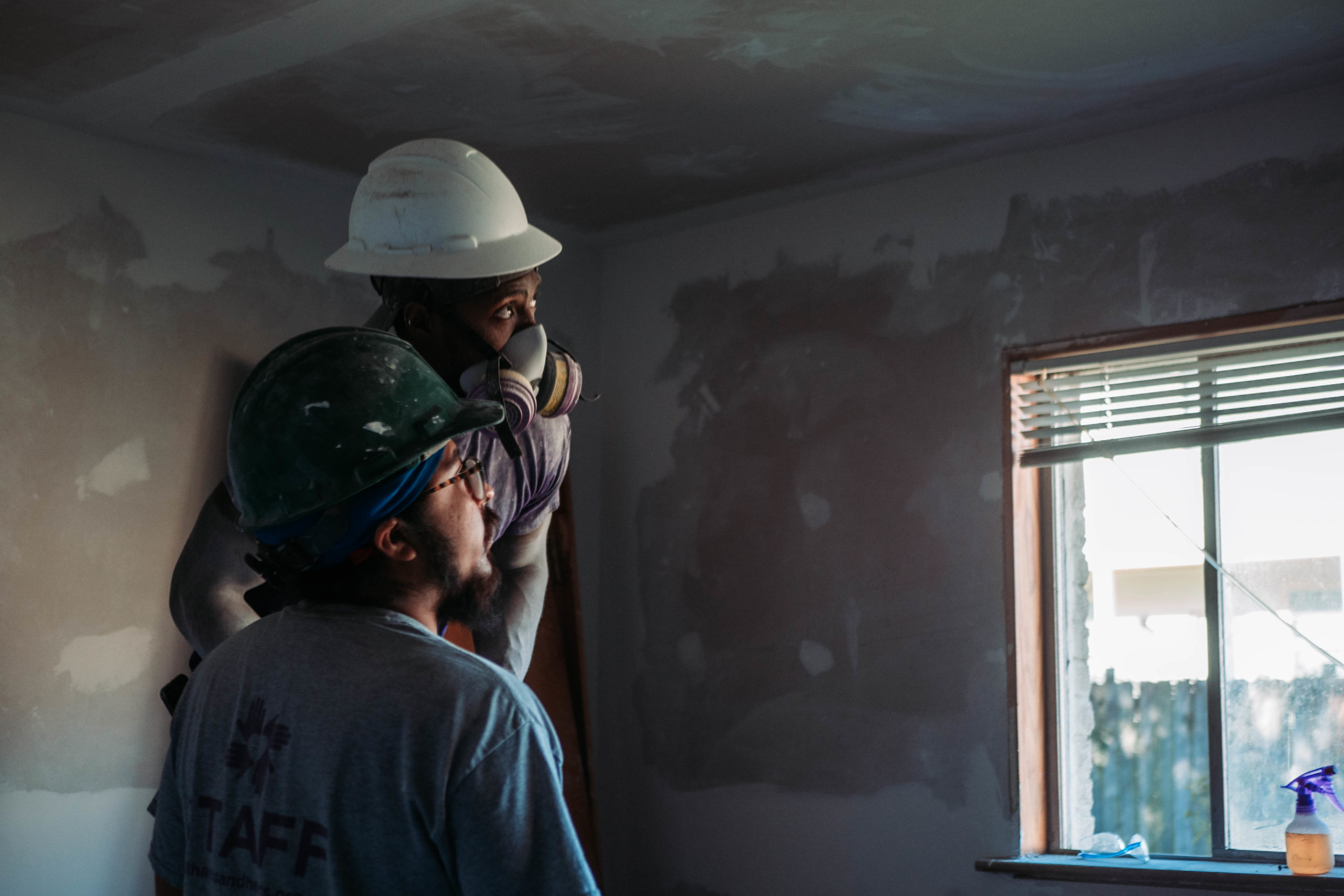 dos personas mirando a una ventana con cascos