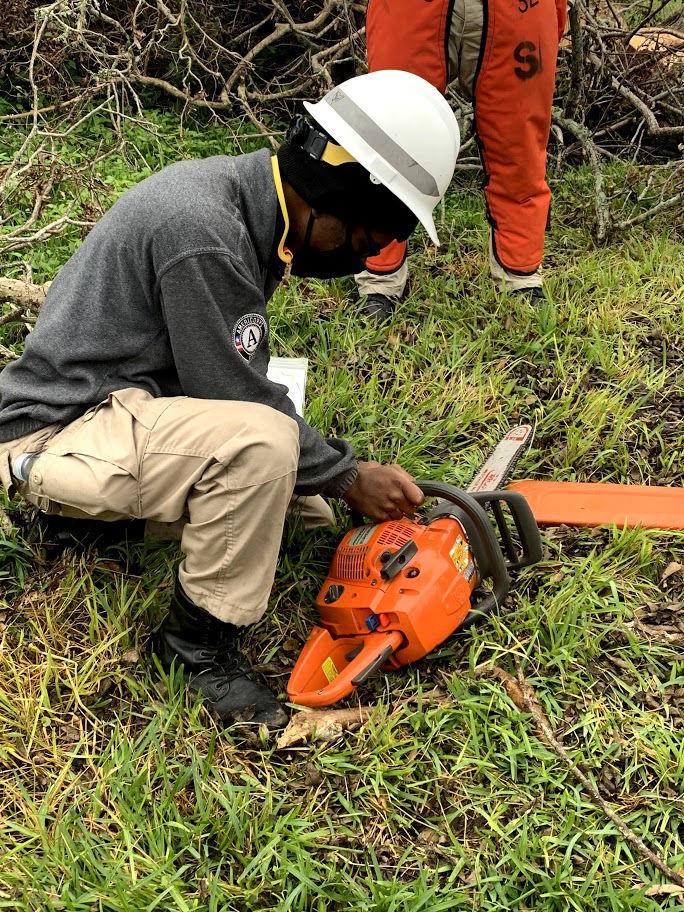 NCCC volunteer working on a chainsaw