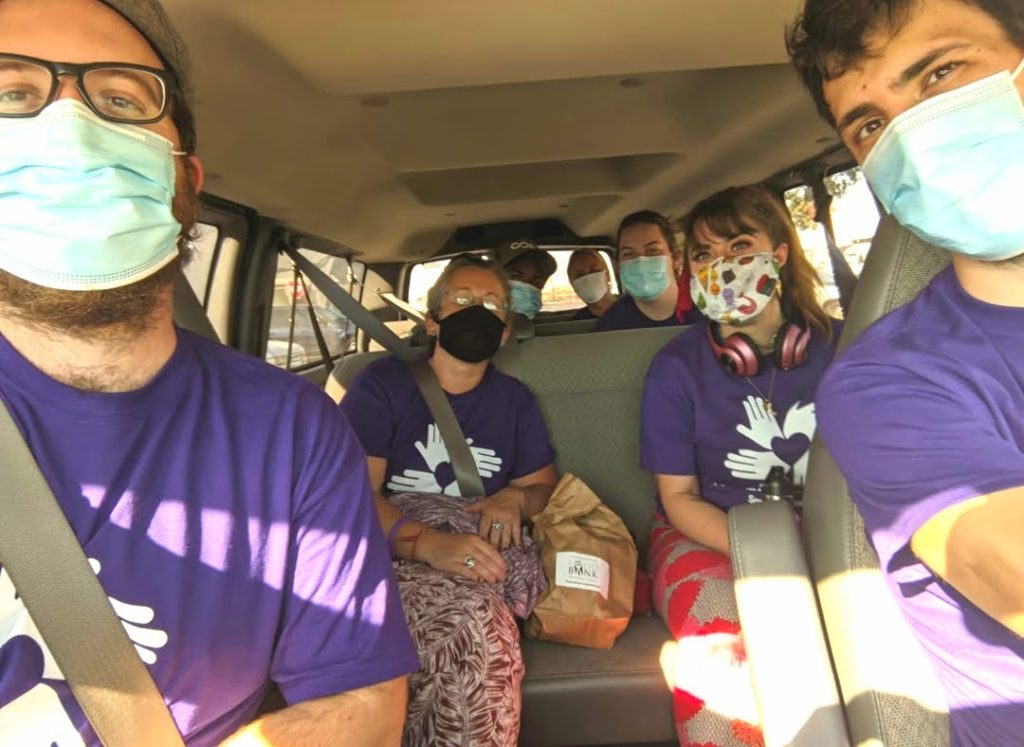 voluntarios enmascarados en una furgoneta de camino al trabajo