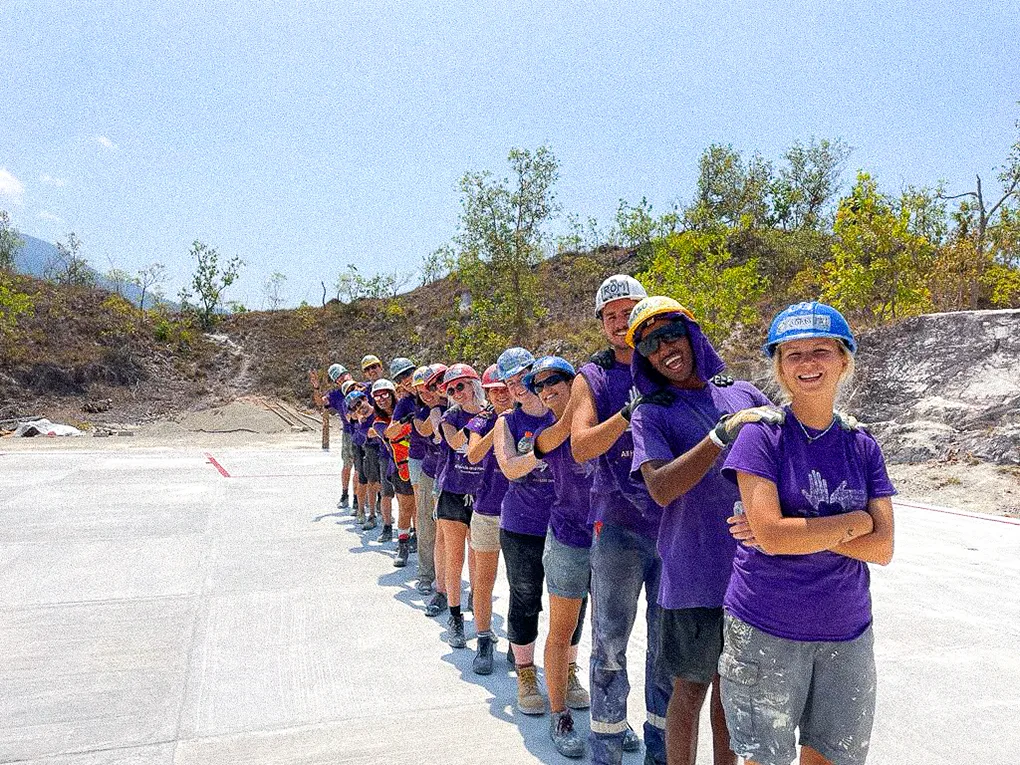 A line of volunteers pose smiling