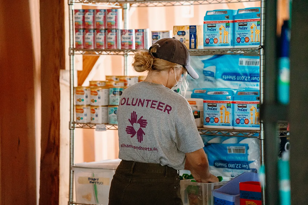AHAH volunteer sorting food products at a community resource hub