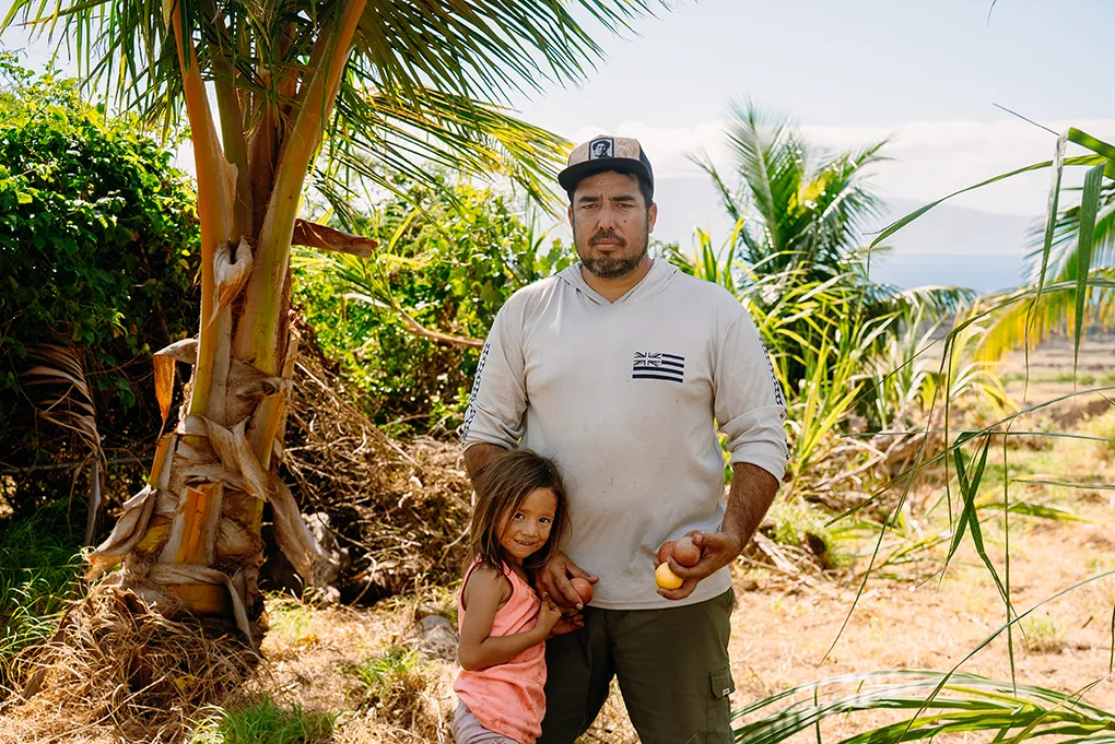 Hawaiian man and daughter posing for photo on a beach