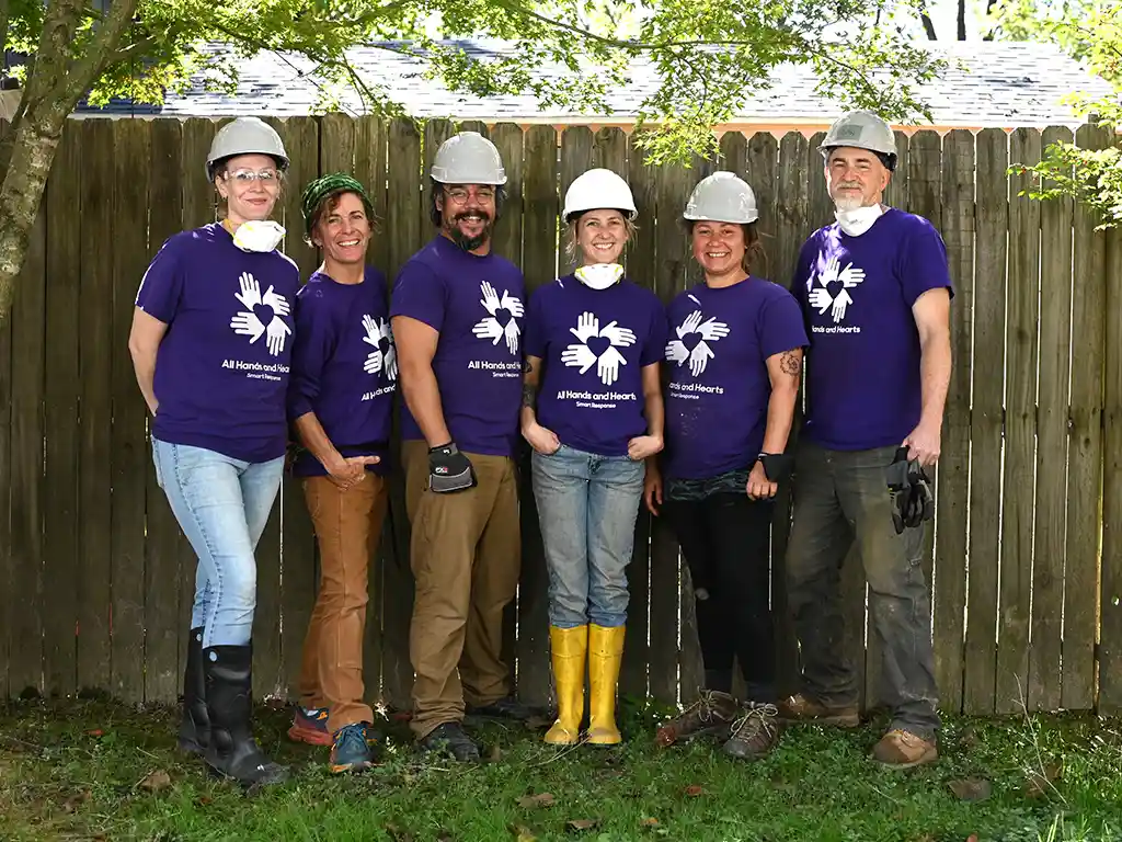 Group of volunteers pose for the camera in a backyard